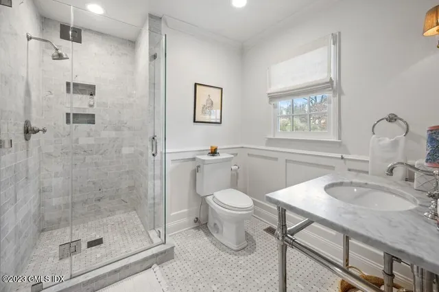 a bathroom with a granite countertop sink a toilet and shower