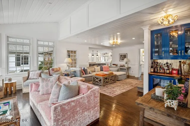 a living room with furniture kitchen and a large window