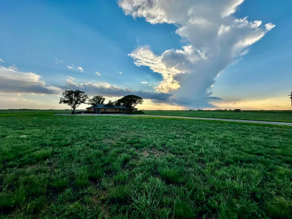 a view of a big yard of grass and an fountain