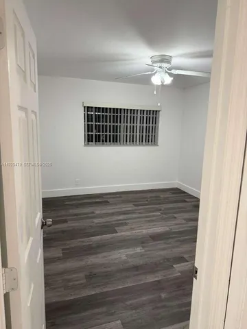 a view of a room with wooden floor and white walls