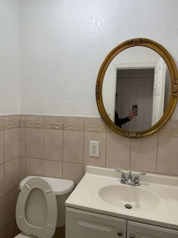 a bathroom with a sink mirror and toilet