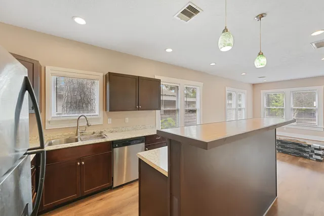 a kitchen with granite countertop a sink stainless steel appliances and cabinets