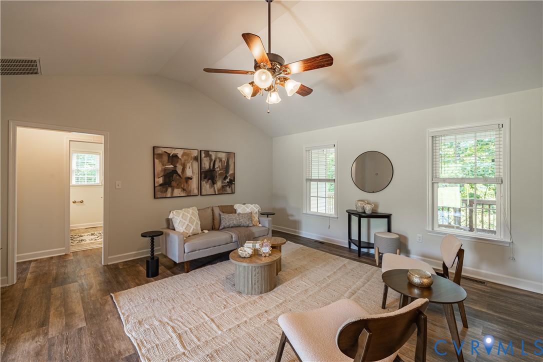 Vaulted ceiling with a ceiling fan, wood-finish fl