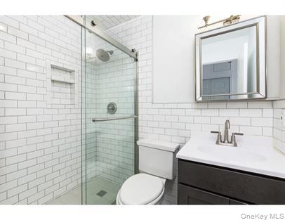 a bathroom with a sink mirror toilet and shower