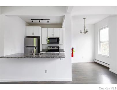 144 Union Street, Unit 6 Poughkeepsie, NY 12601 - Photo 3 of 9 a kitchen with stainless steel appliances kitchen island granite countertop a refrigerator sink and microwave