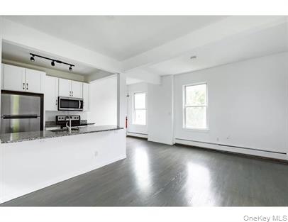 144 Union Street, Unit 6 Poughkeepsie, NY 12601 - Photo 5 of 9 a kitchen with stainless steel appliances a refrigerator and a stove top oven
