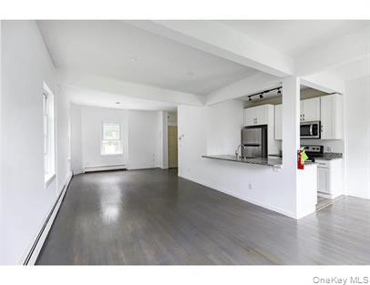 144 Union Street, Unit 6 Poughkeepsie, NY 12601 - Photo 6 of 9 a view of a living room a kitchen with wooden floor and a window