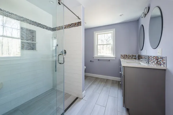 a bathroom with a sink a mirror and a shower