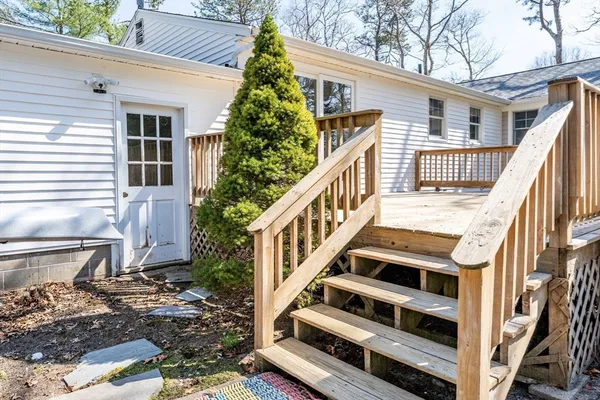 a view of a house with wooden stairs and a small yard