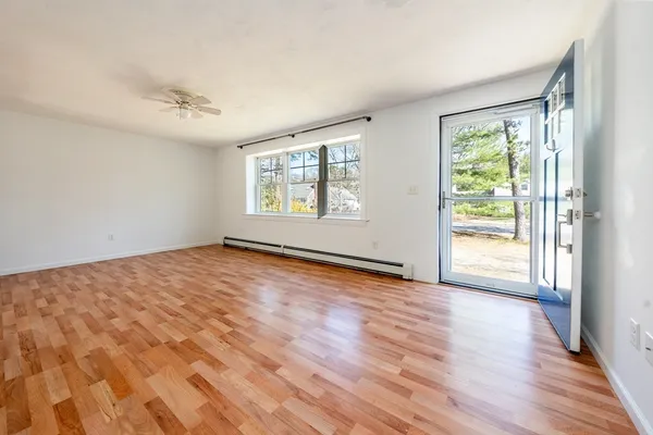 an empty room with wooden floor and windows