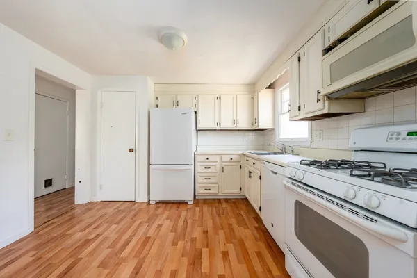 a kitchen with white cabinets and stainless steel appliances