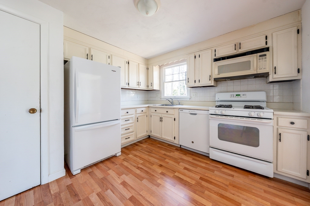 67 Crawford Road Barnstable, MA 02635 - Photo 8 of 26 a kitchen with white cabinets and white stainless steel appliances