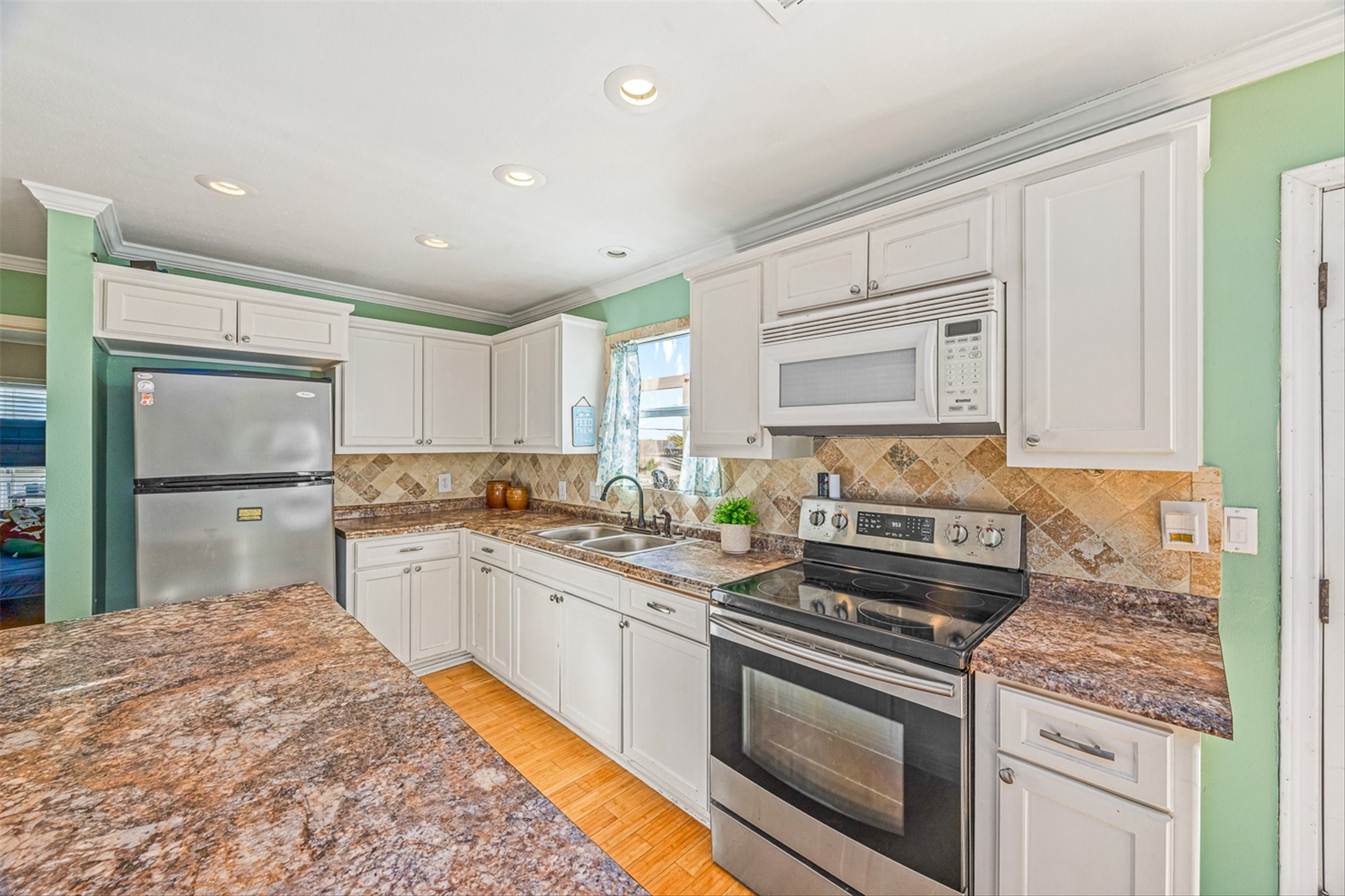 159 Garth Street Freeport, TX 77541 - Photo 25 of 42 a kitchen with stainless steel appliances granite countertop a stove a sink and a refrigerator