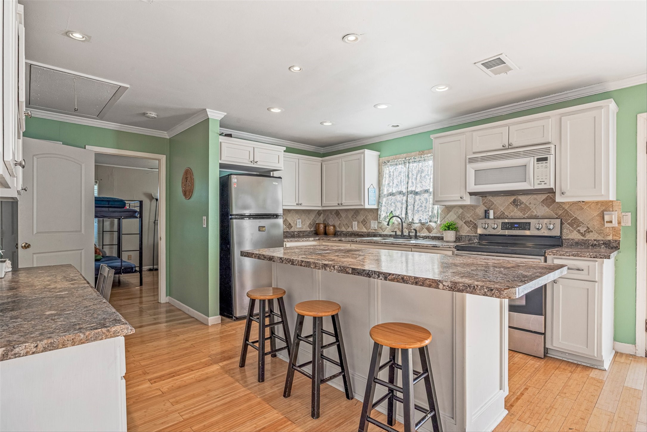 159 Garth Street Freeport, TX 77541 - Photo 27 of 42 a kitchen with stainless steel appliances granite countertop a table chairs sink refrigerator and cabinets