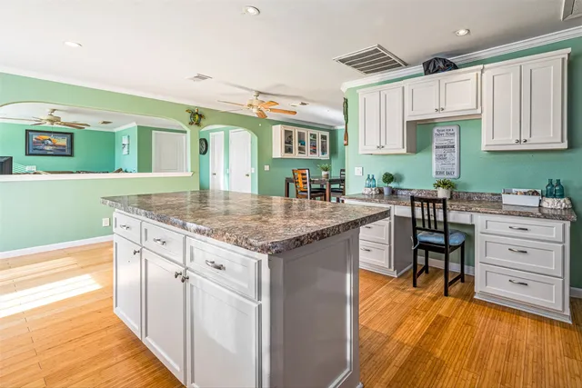 a kitchen with granite countertop a stove and a wooden floors