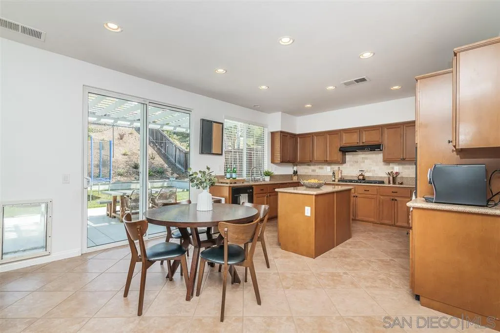 1022 Greenway Road Oceanside, CA 92057 - Photo 9 of 25 a kitchen with a table chairs sink and cabinets