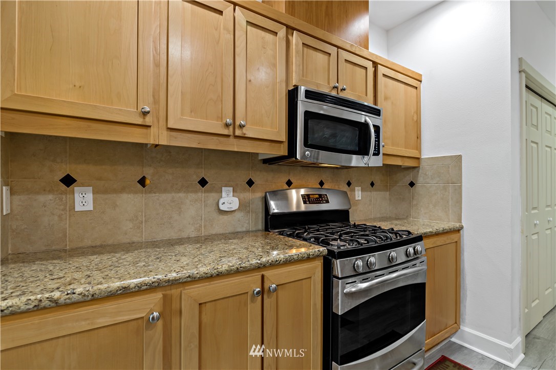 19102 20th Drive Southeast, Unit B204 Bothell, WA 98012 - Photo 11 of 30 a kitchen with granite countertop cabinets stainless steel appliances and a sink