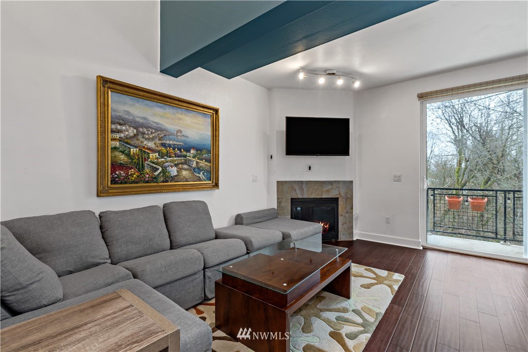 19102 20th Drive Southeast, Unit B204 Bothell, WA 98012 - Photo 3 of 30 a living room with furniture a flat screen tv and a fireplace