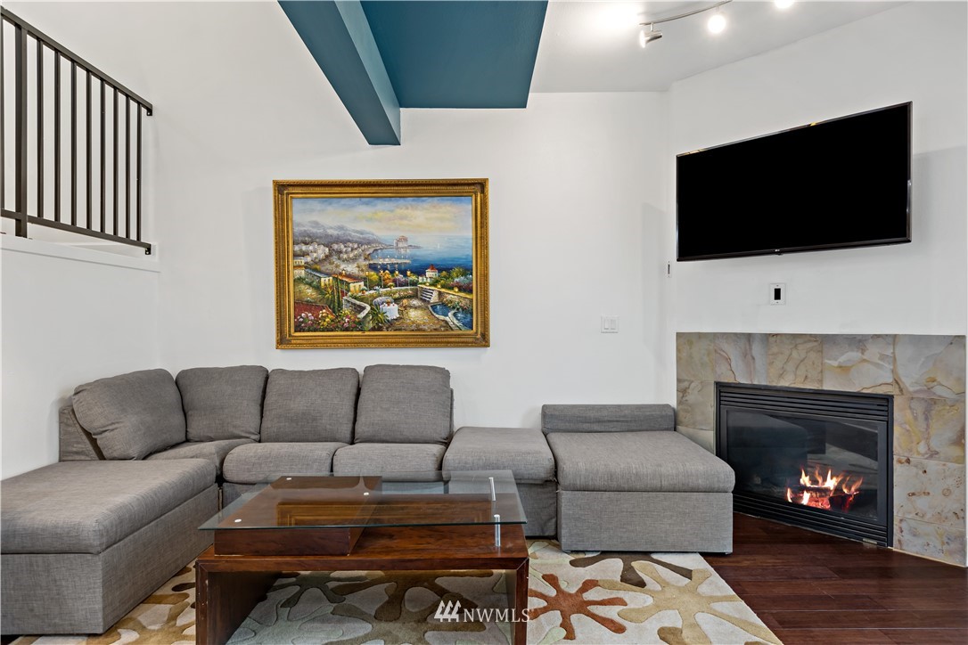 19102 20th Drive Southeast, Unit B204 Bothell, WA 98012 - Photo 4 of 30 a living room with furniture a flat screen tv and a fireplace