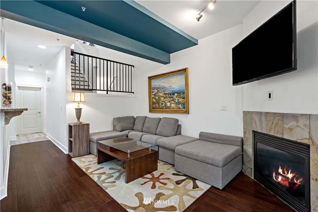 19102 20th Drive Southeast, Unit B204 Bothell, WA 98012 - Photo 5 of 30 a living room with furniture a flat screen tv and a fireplace