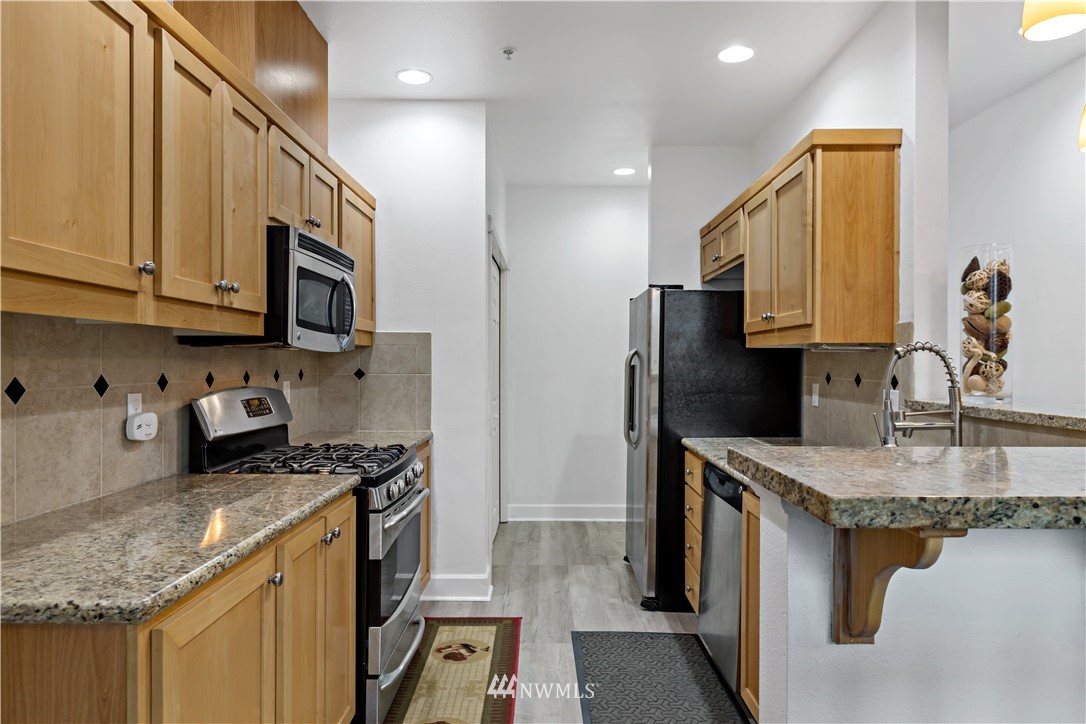 19102 20th Drive Southeast, Unit B204 Bothell, WA 98012 - Photo 9 of 30 a kitchen with stainless steel appliances granite countertop a sink stove and refrigerator