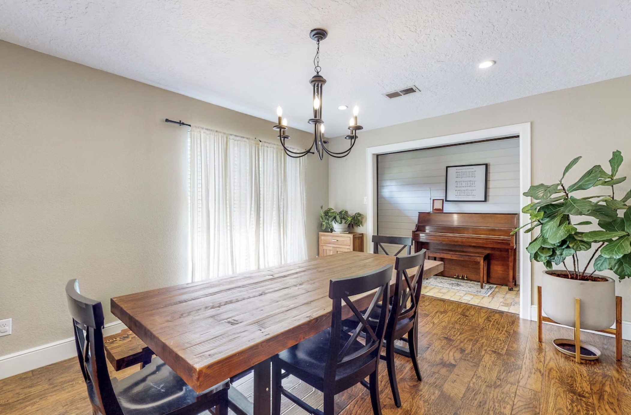 30819 Quinn Road Tomball, TX 77375 - Photo 10 of 30 a dining room with wooden floor a chandelier a wooden table and chairs
