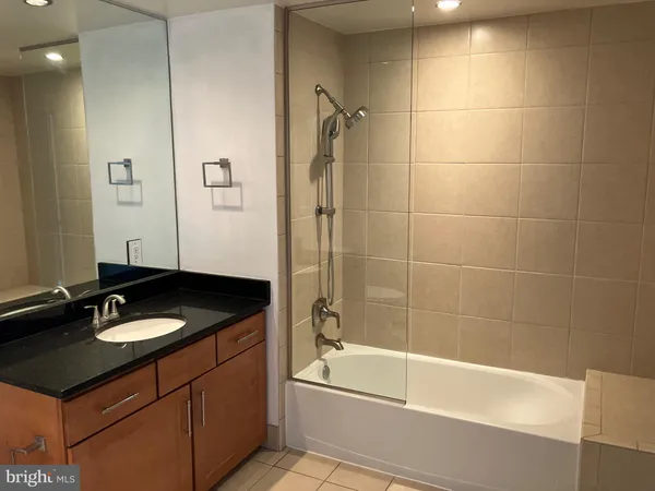 a bathroom with a granite countertop sink a toilet and bathtub