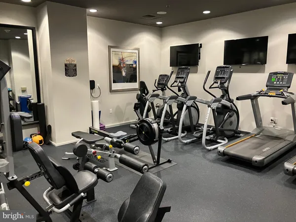 a room with gym equipment and a flat screen tv
