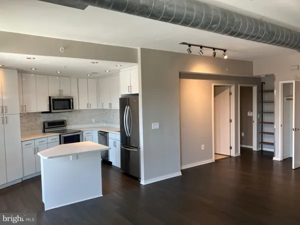 a kitchen with stainless steel appliances kitchen island granite countertop a refrigerator and a stove top oven