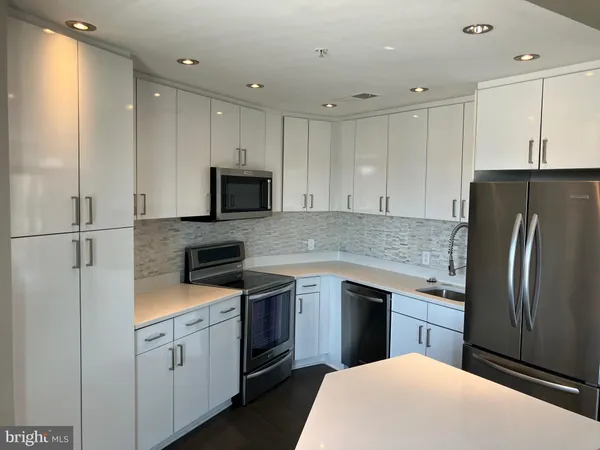a kitchen with stainless steel appliances granite countertop a refrigerator sink and cabinets