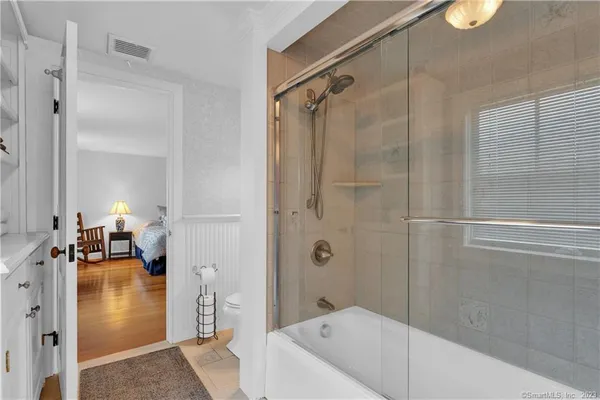 a bathroom with a double vanity sink mirror and next to a window