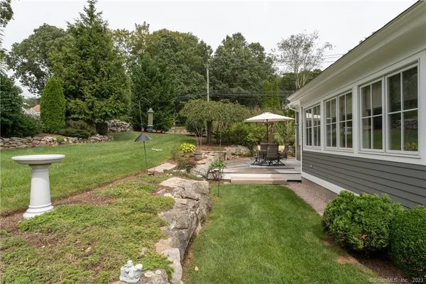 a view of a chair and table in backyard of the house