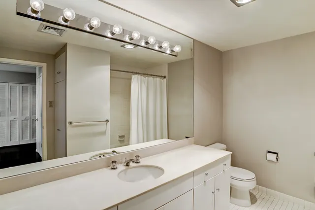 a bathroom with a sink vanity granite and toilet