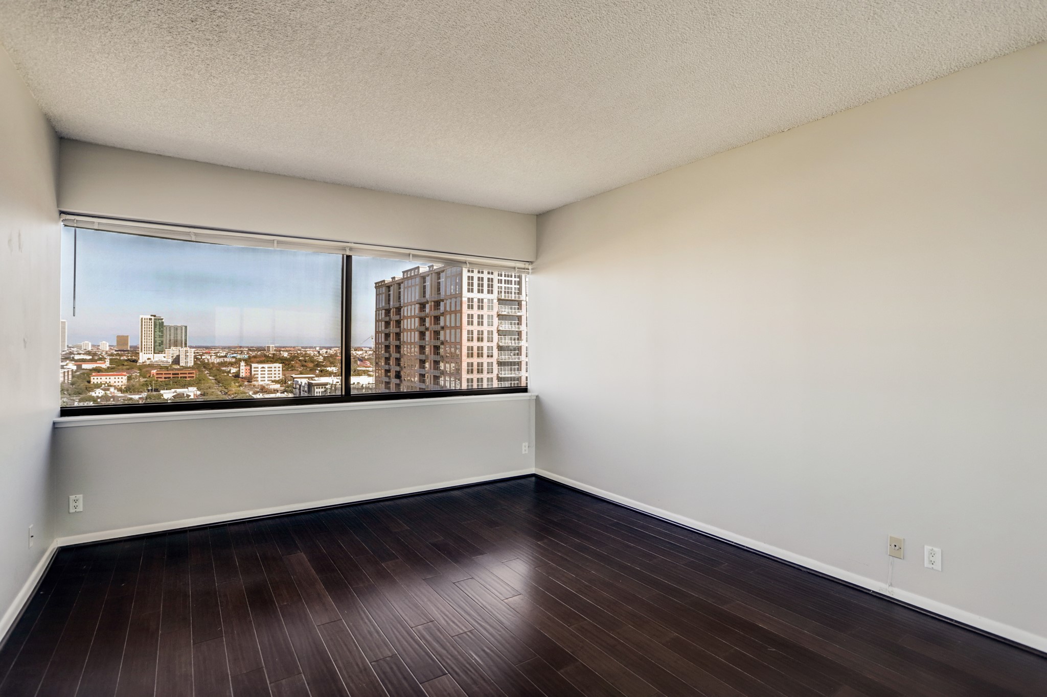 5000 Montrose Boulevard, Unit 18A Houston, TX 77006 - Photo 8 of 14 a view of an empty room with wooden floor and a window