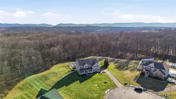 a view of a livingroom and dining room with furniture wooden floor and windows