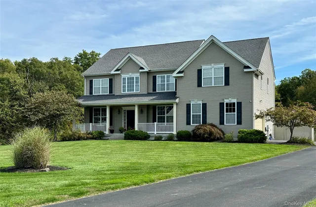 a front view of a house with garden and trees