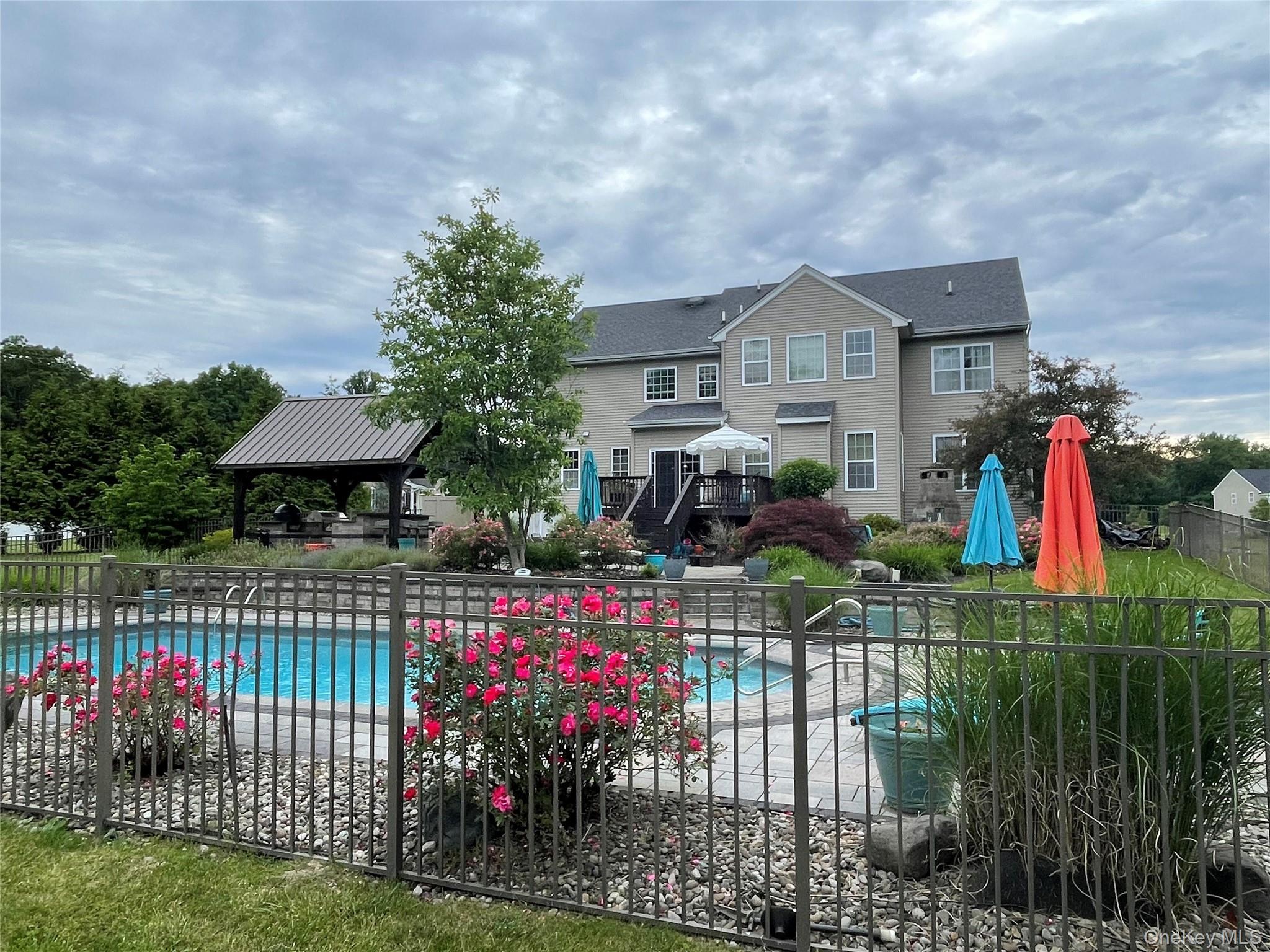 102 Luthien Forrest Road Rock Tavern, NY 12575 - Photo 5 of 45 a view of a house with a flower garden and a wooden fence