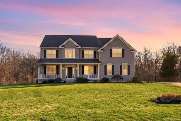 a front view of a house with a yard and potted plants