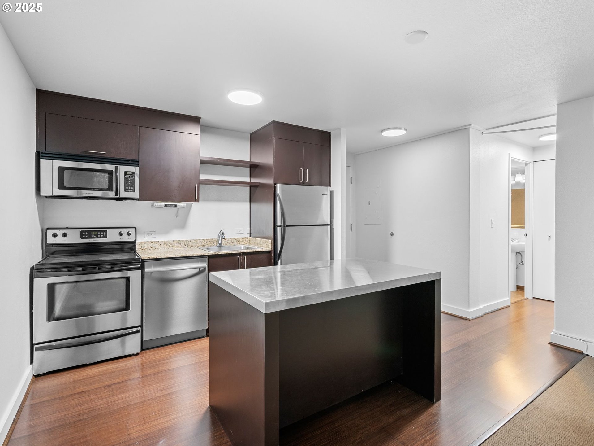 255 Southwest Harrison Street, Unit 3C Portland, OR 97201 - Photo 12 of 32 a kitchen with stainless steel appliances kitchen island sink refrigerator and cabinets