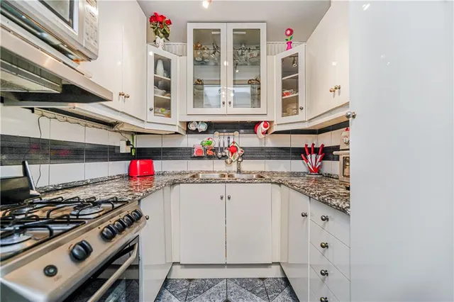 a kitchen with stainless steel appliances granite countertop a sink stove and cabinets