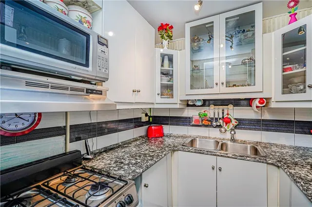 a kitchen with stainless steel appliances granite countertop a sink stove and cabinets