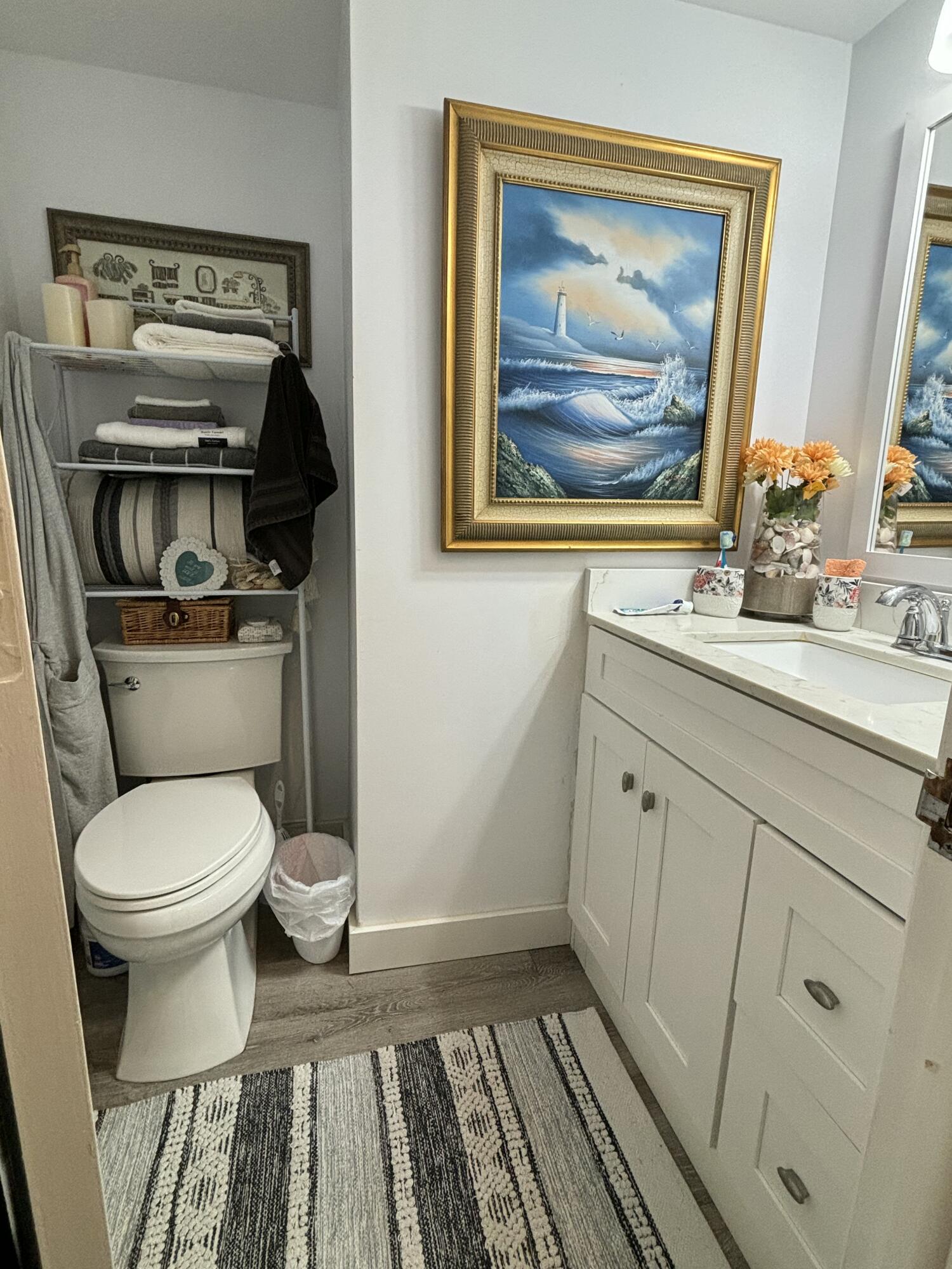 331 Southwest 8th Street, Unit 2CE Boca Raton, FL 33432 - Photo 9 of 19 a bathroom with a toilet a sink and glass door
