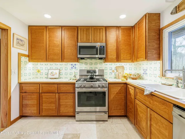 a kitchen with stainless steel appliances granite countertop wooden cabinets sink and a granite counter top