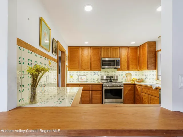 a large kitchen with stainless steel appliances granite countertop a stove and a sink
