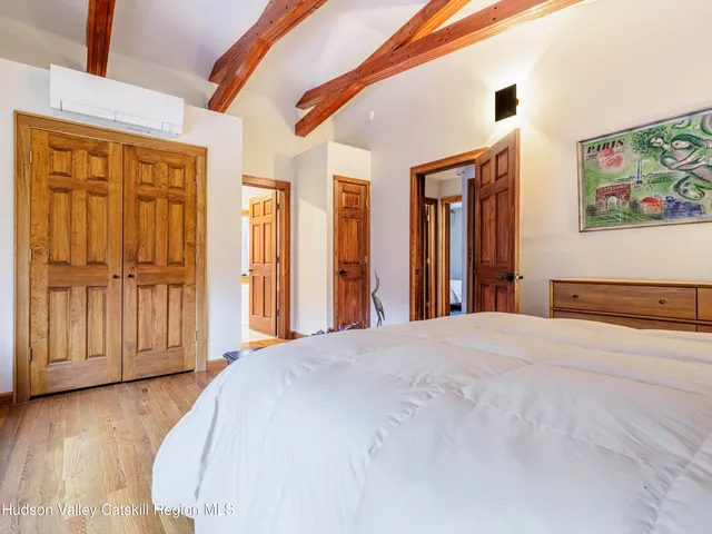 a bedroom with a bed and a painting on the wall