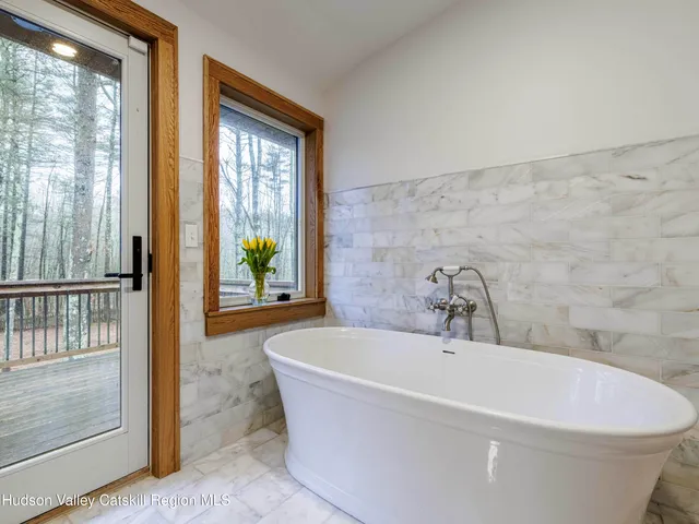 a white bath tub sitting in a bathroom next to a window