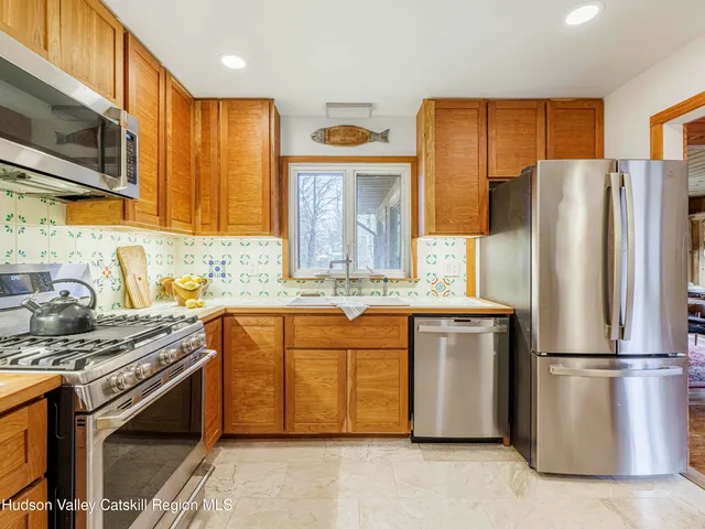 a kitchen with stainless steel appliances granite countertop a refrigerator stove and microwave
