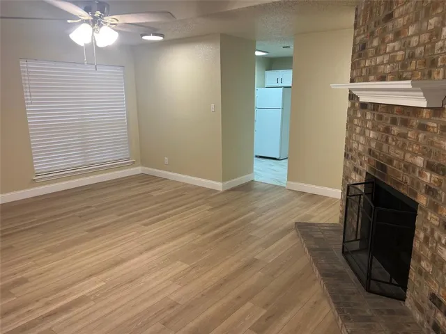 an empty room with wooden floor and fireplace