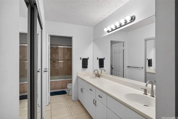 a spacious bathroom with a double vanity sink a mirror and a shower