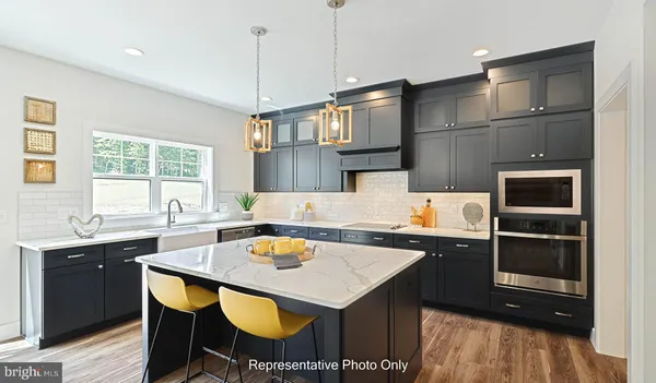 a kitchen with a sink a kitchen island and chairs in it